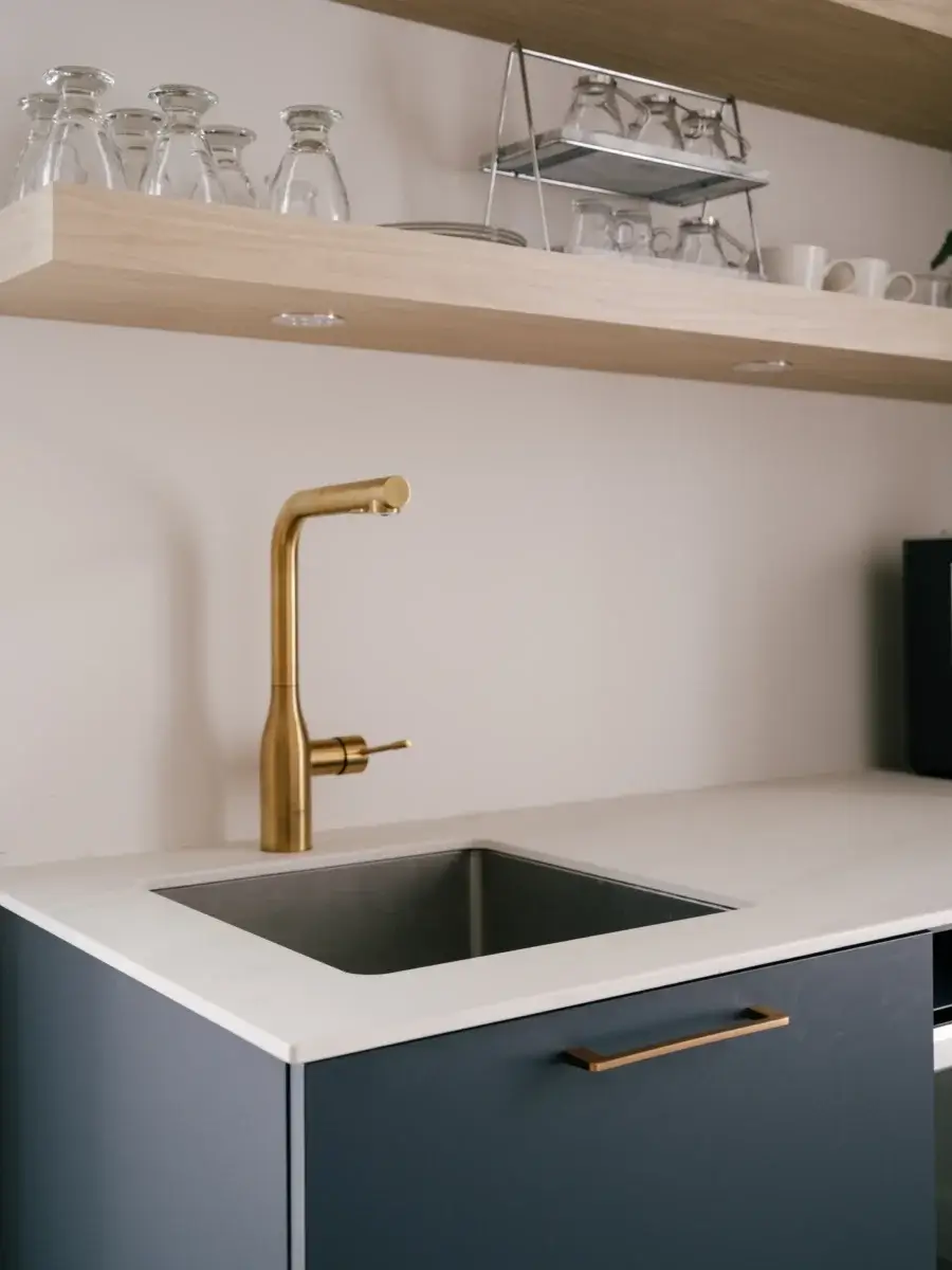 Évier inox avec robinet doré et étagères décoratives en bois – petit coin café élégant par Mathurin cuisines & salles de bains.