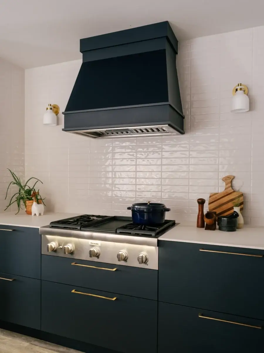 Hotte de cuisine bleu foncé avec mur de céramique blanche texturée – réalisation Kamouraska.