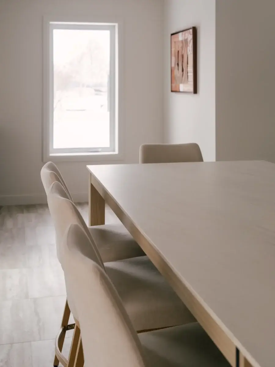 Prolongement de l’îlot de cuisine en effet marbre avec espace repas intégré et chaises rembourrées – cuisine Kamouraska par Mathurin cuisines & salles de bains.