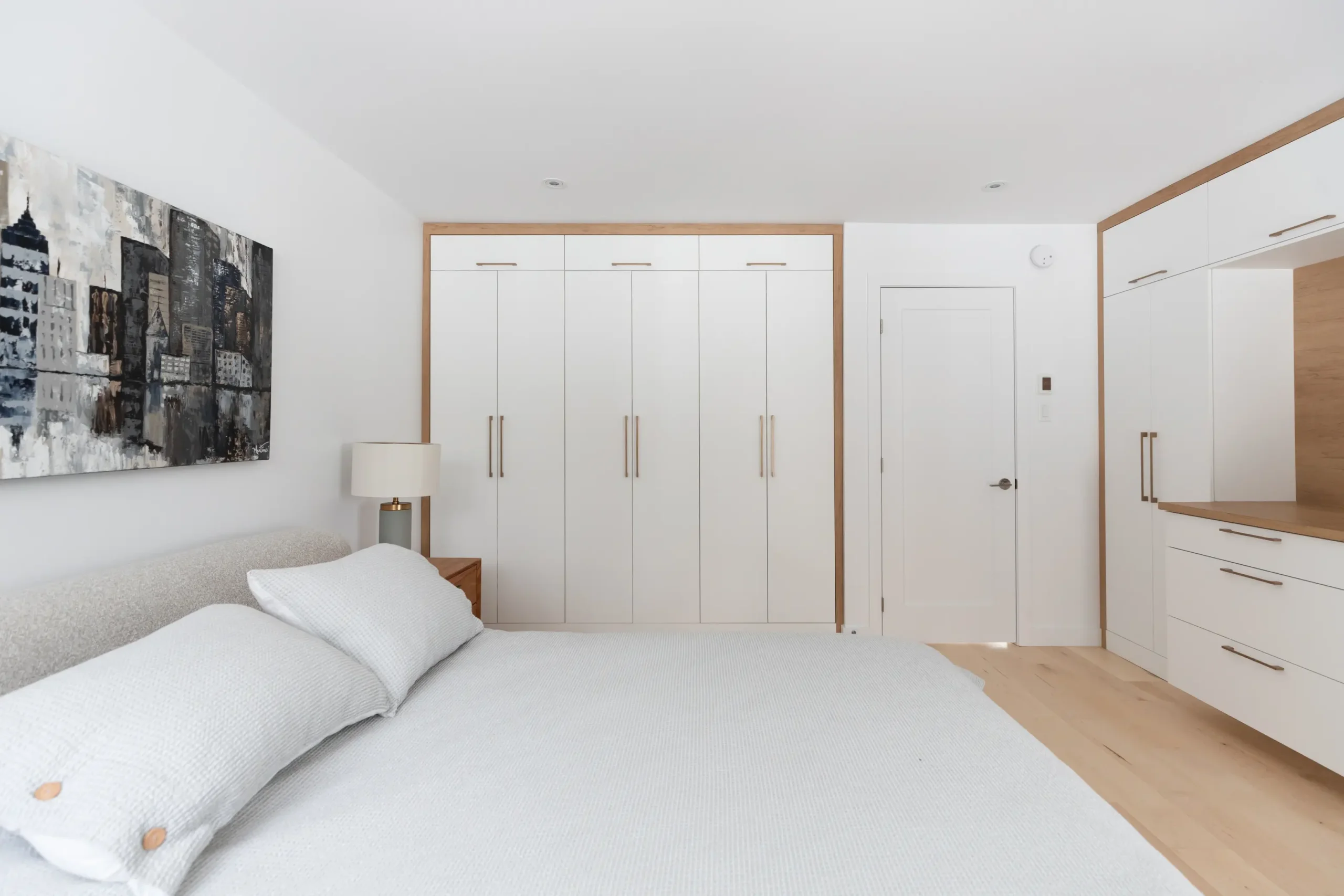 Chambre des maîtres à Québec avec meubles sur mesure blancs et bois clair – conception Mathurin cuisines & salles de bains.