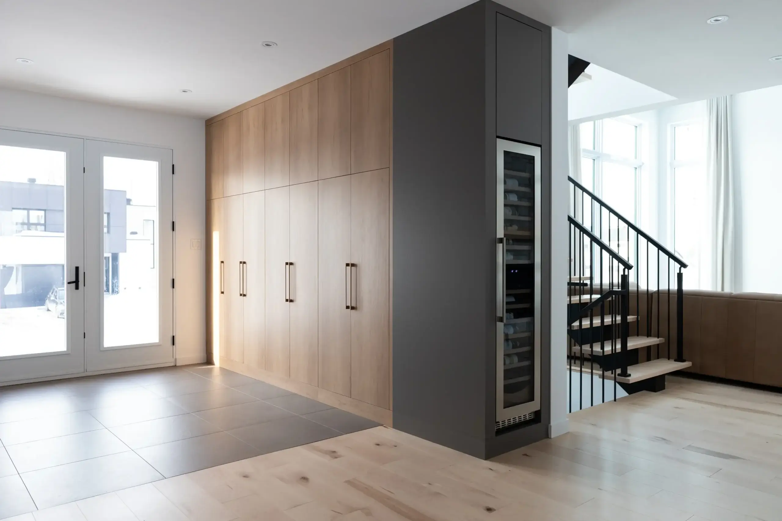 Meuble d’entrée effet bois naturel sur mesure avec armoires pleine hauteur dans une maison neuve à Québec.