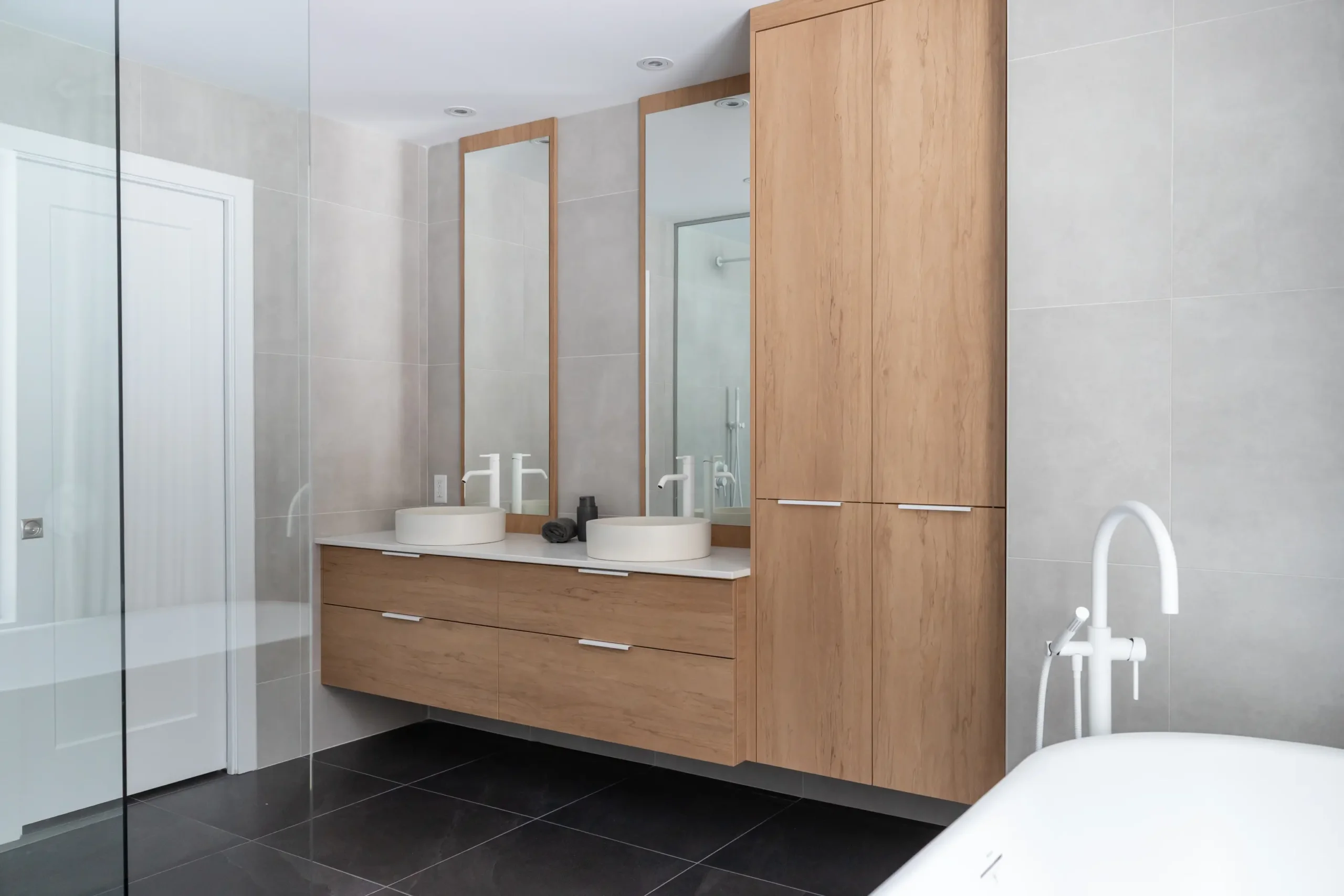 Vanité suspendue avec lavabos ronds et grands miroirs – salle de bain sur mesure à Québec.