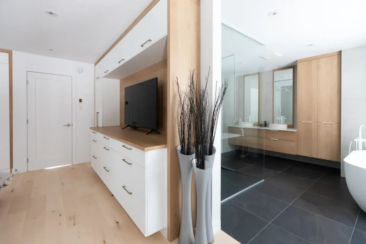 Mobilier sur mesure à Québec reliant chambre et salle de bain, avec TV intégrée et design harmonisé.