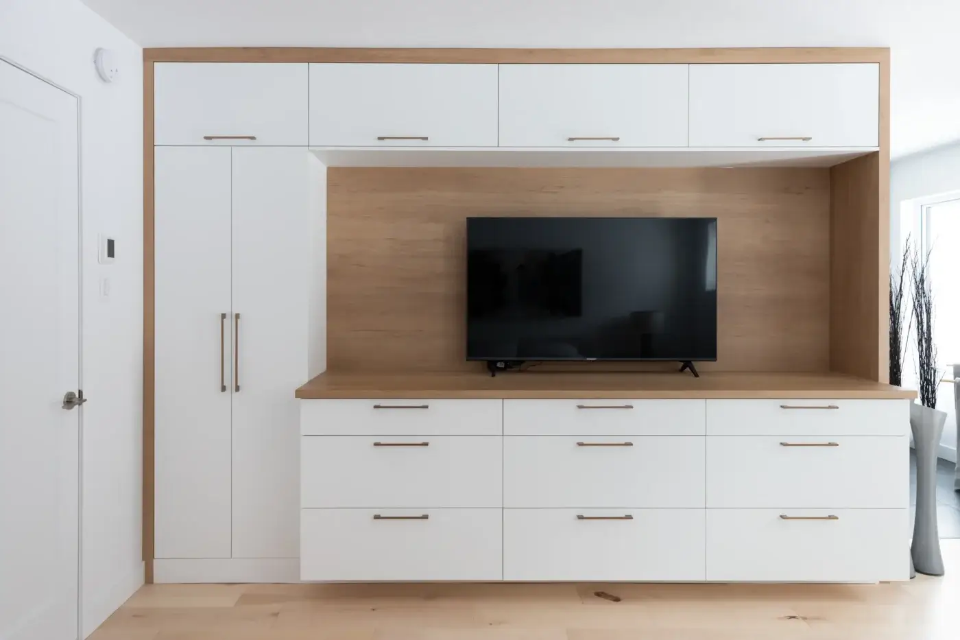 Unité murale sur mesure blanche et bois clair pour téléviseur – chambre des maîtres à Québec.