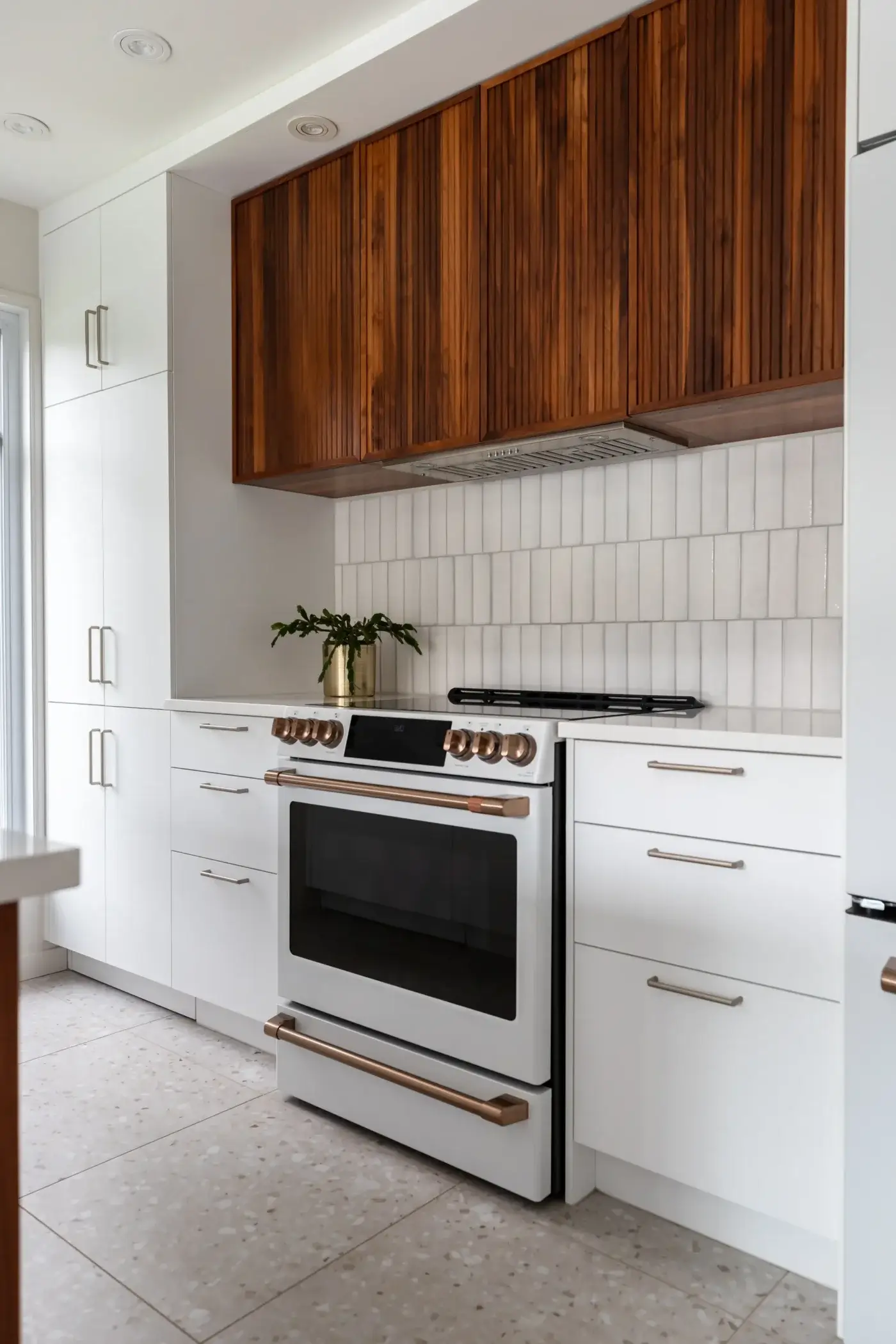 Armoires en noyer au-dessus de la cuisinière avec hotte encastrée.