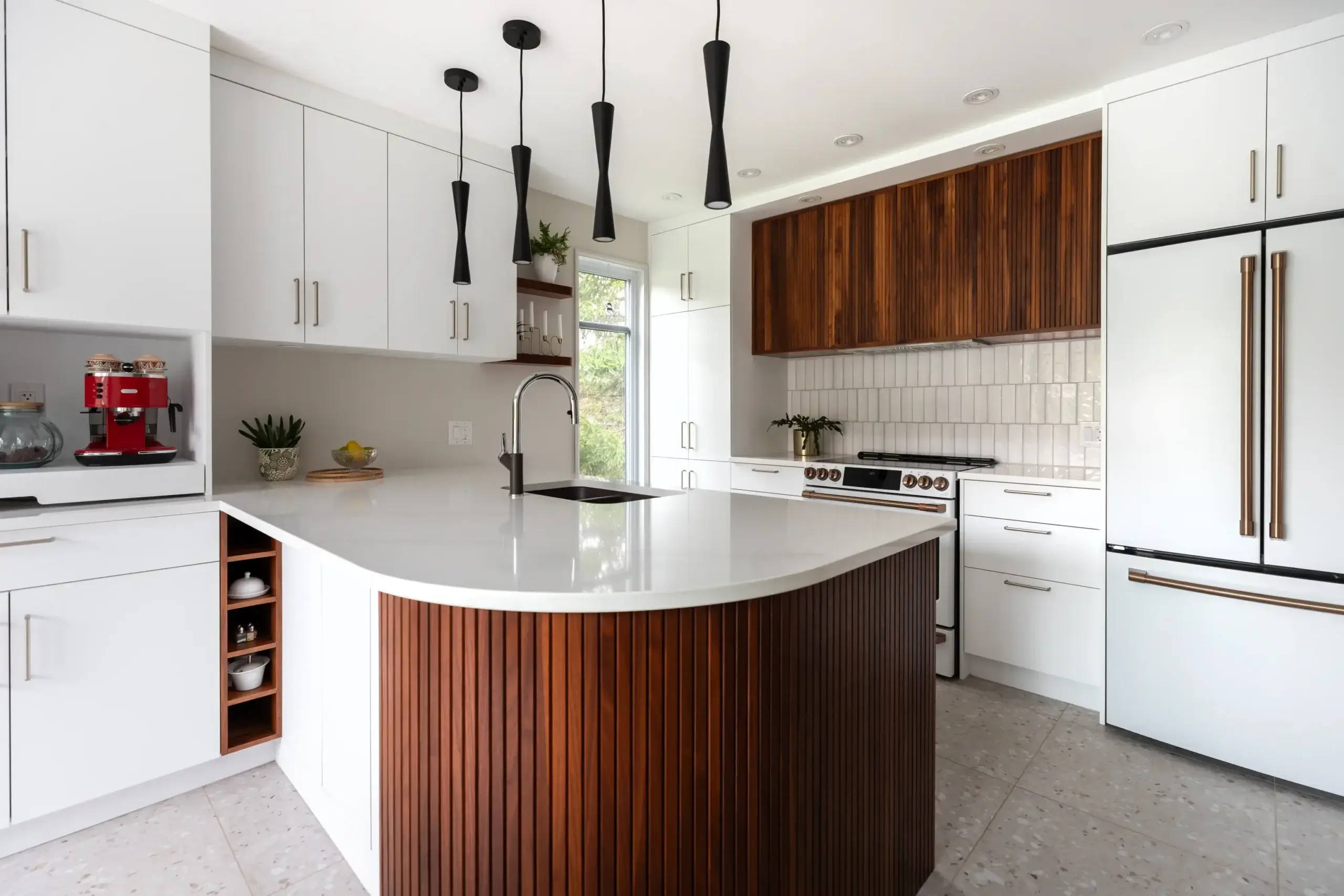 Une cuisine avec des comptoirs de quartz blanc et un ilot en noyer.