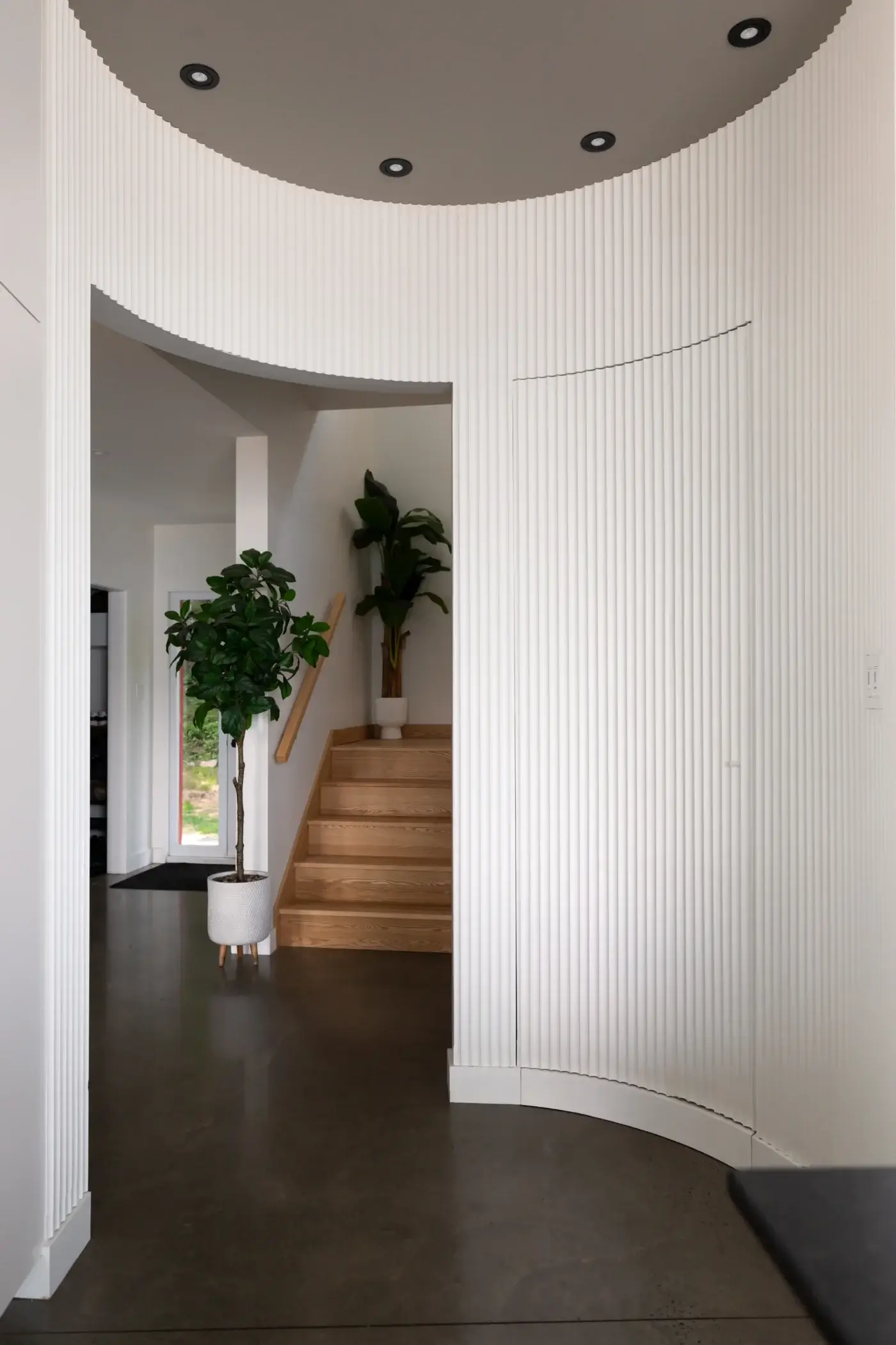 Entrée dissimulée d’un garde-manger walk-in derrière des lattes courbées