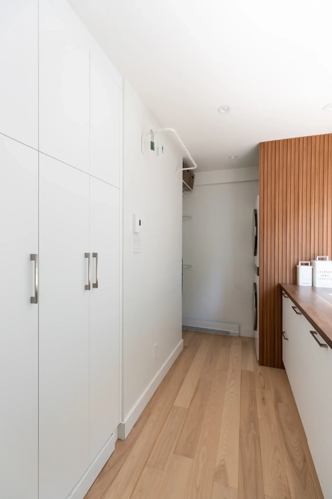 Armoires blanches sur mesure dans salle de lavage contemporaine.